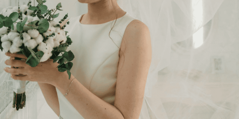 A bride in a white dress holds a bouquet