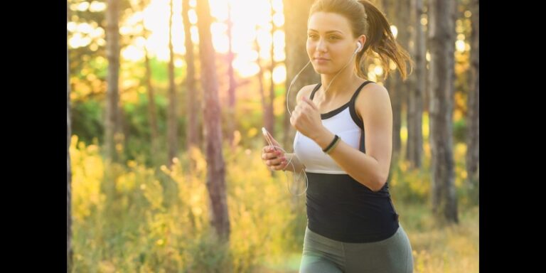Woman jogging outdoors with earphones to stay healthy and prevent disease.