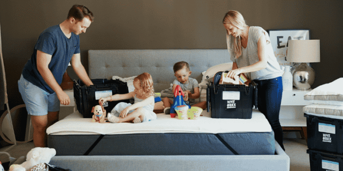 A happy family organizing and unpacking in a bedroom, showing how a holiday home helps them connect.