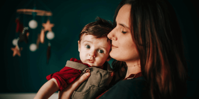 A mother lovingly holding her baby, symbolizing the nurturing connection at the heart of gentle parenting.