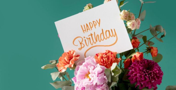 Happy Birthday Card with Colorful Flowers on Green Background Bouquet of colorful flowers with a Happy Birthday card on a green background