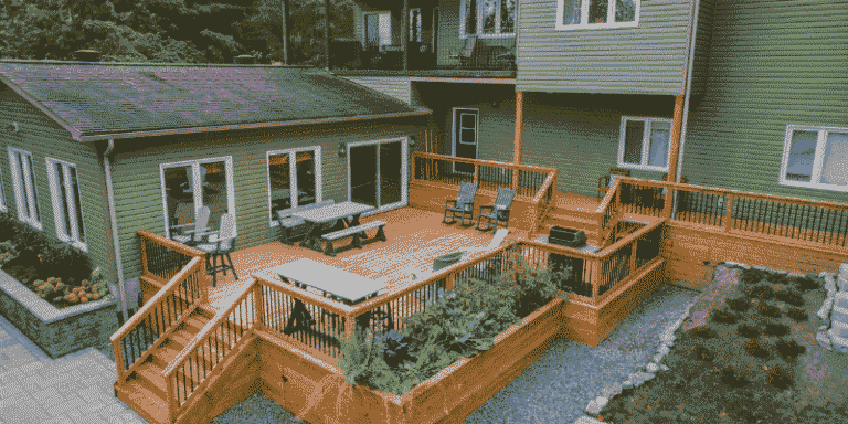 A large backyard deck with multiple levels, outdoor chairs, and landscaped surroundings, adding value to a modern home.