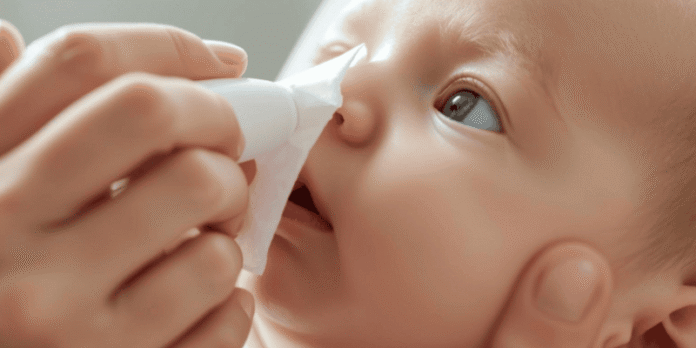 Parent gently using a nasal spray to help a baby breathe easier with natural care methods.