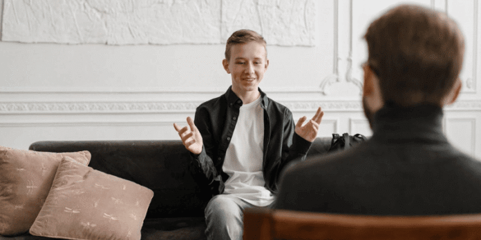 Counselor speaking with a young client in a modern therapy session,