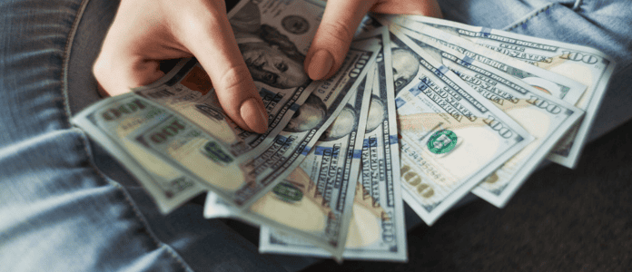 A Person holding multiple US dollar notes