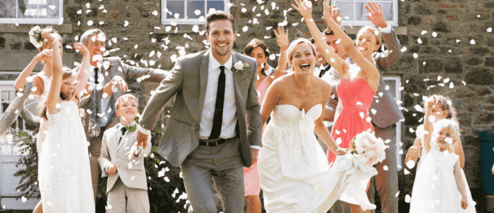 Bride and groom celebrating with family and children at a joyful outdoor wedding, representing a family-friendly venue.