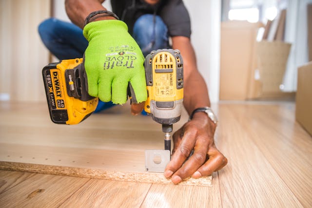 Easy Upgrades That Improve Your Home A contractor using a power drill to install hardware, representing easy and practical home improvement work.
