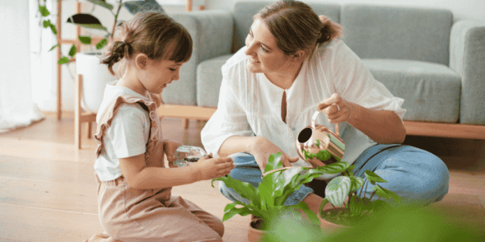 Mother and young child watering plants together at home
