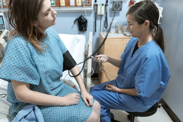 Clinical Readiness in a Fast-Paced Healthcare Setting A doctor checking a patient’s vital signs in a hospital room, highlighting the importance of clinical readiness in busy healthcare environments.