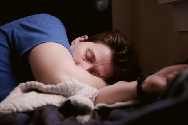 A person sleeping deeply on a bed with soft lighting Falling Asleep Quickly After a Long Day