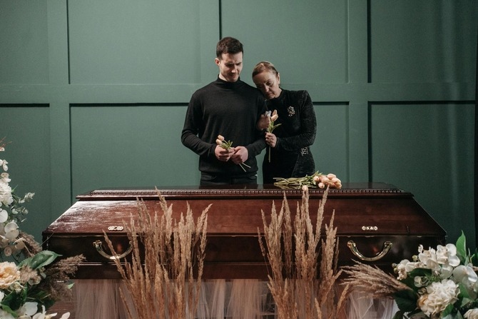 Direct Cremation Explained: Services, Costs, and Expectations Family members standing beside a casket during a funeral service, illustrating end-of-life planning and the differences between traditional funeral arrangements and direct cremation.